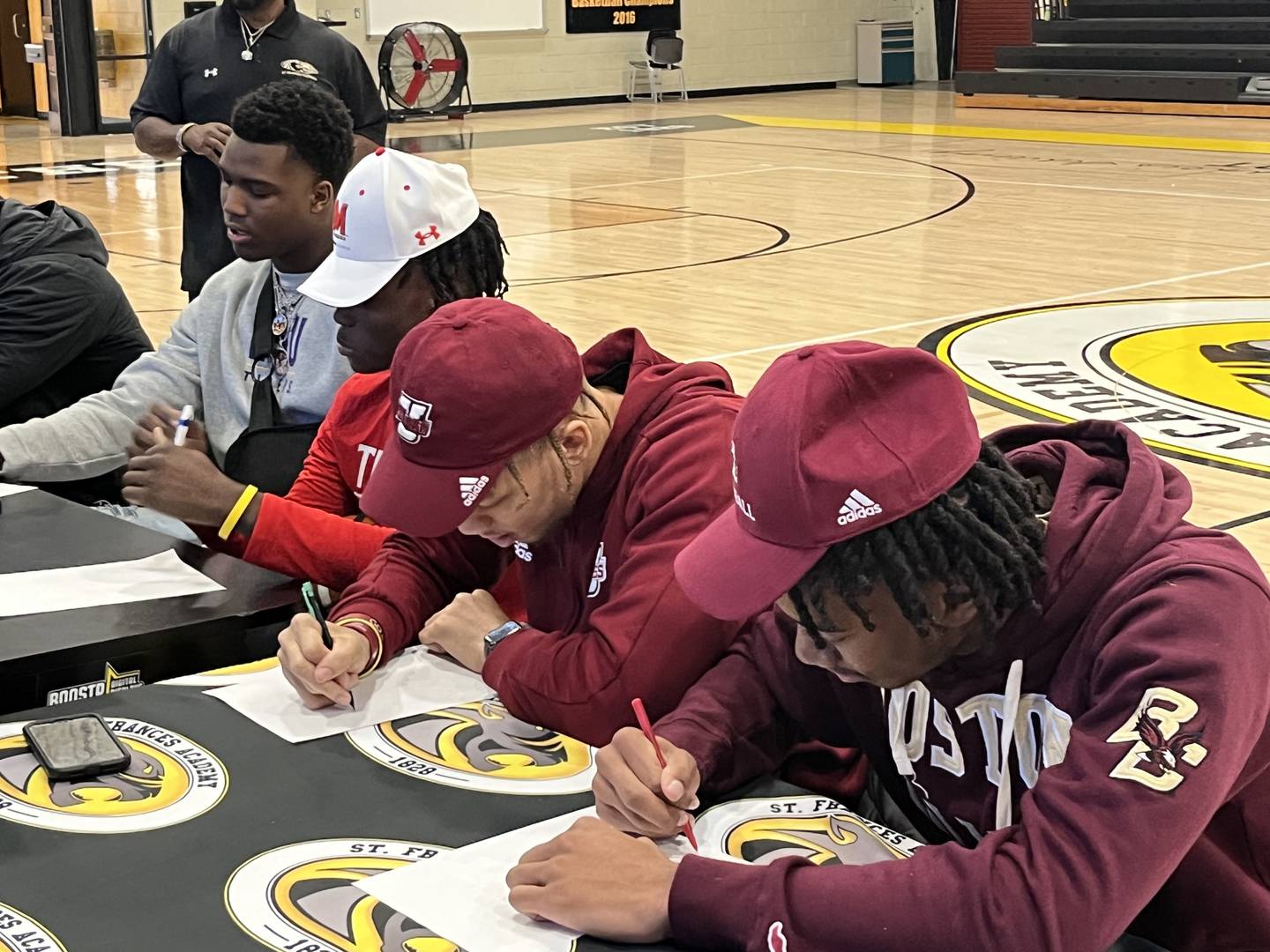 Da'Shawn Womack (left), Ryan Manning, Donovan Dyson and K.P. Price sign scholarship letters during a ceremony inside St. Frances' gym Wednesday afternoon. Womack signed with LSU with Manning headed to Maryland, Dyson to UMASS and Price to Boston College.