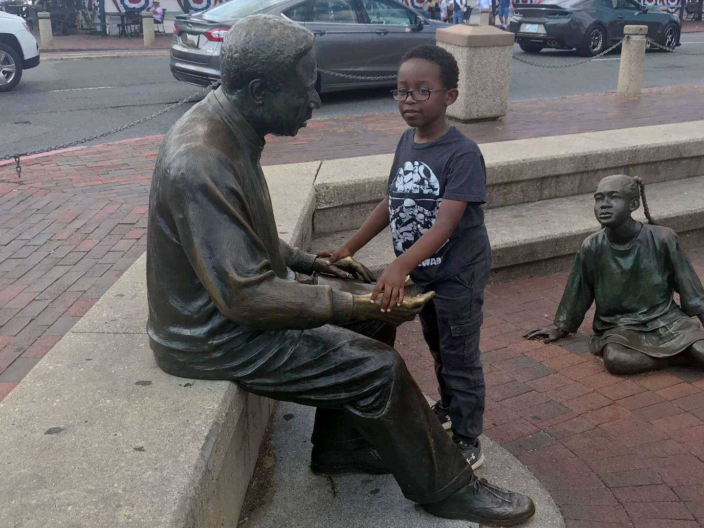Photo of a child with the Alex Haley statue in Annapolis.