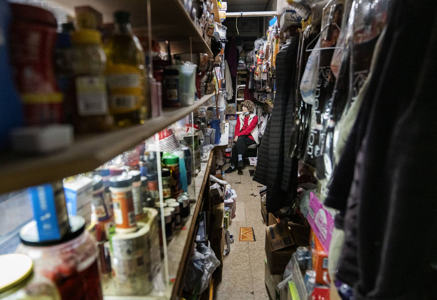 Yong Sun Pak sits waiting for customers at Lee's Mini Market, in Baltimore, Thursday, December 1, 2022.