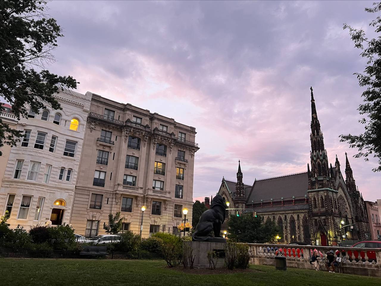 The sky turns purple at dusk behind buildings and a tall church spire.