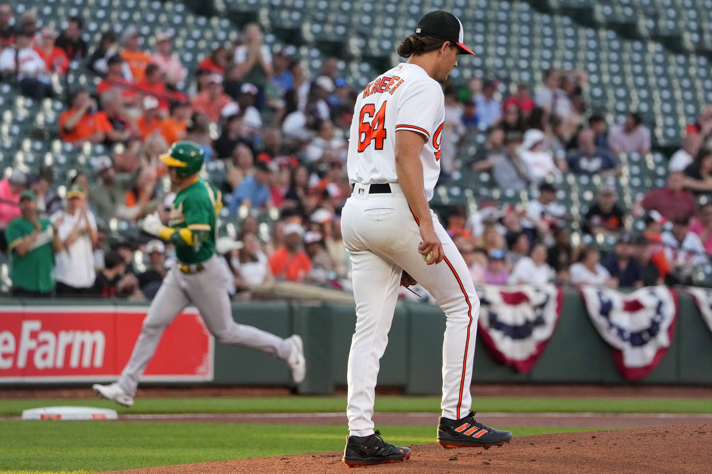 Baltimore Orioles starting pitcher Dean Kremer (64) returns to the mound after Oakland Athletics infielder Brent Rooker (25) homers in the first inning of a baseball game at Camden Yards on Wednesday, April 12. This was the third game in a series the Orioles played against the Athletics.