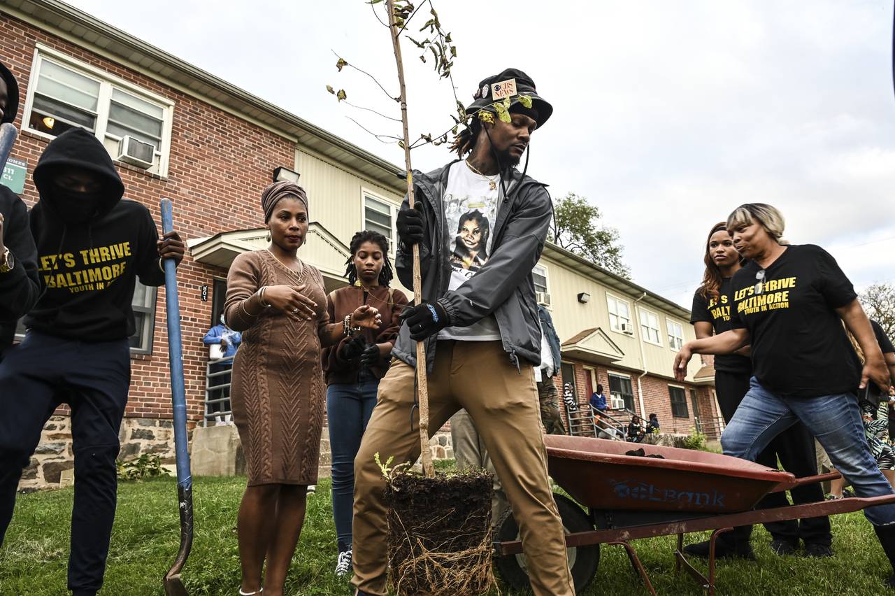 Family members of Aaliyah Gonzalez, who was killed in the Brooklyn Homes shooting in July, plant a tree in her memory at the Brooklyn Healing Day event on Saturday