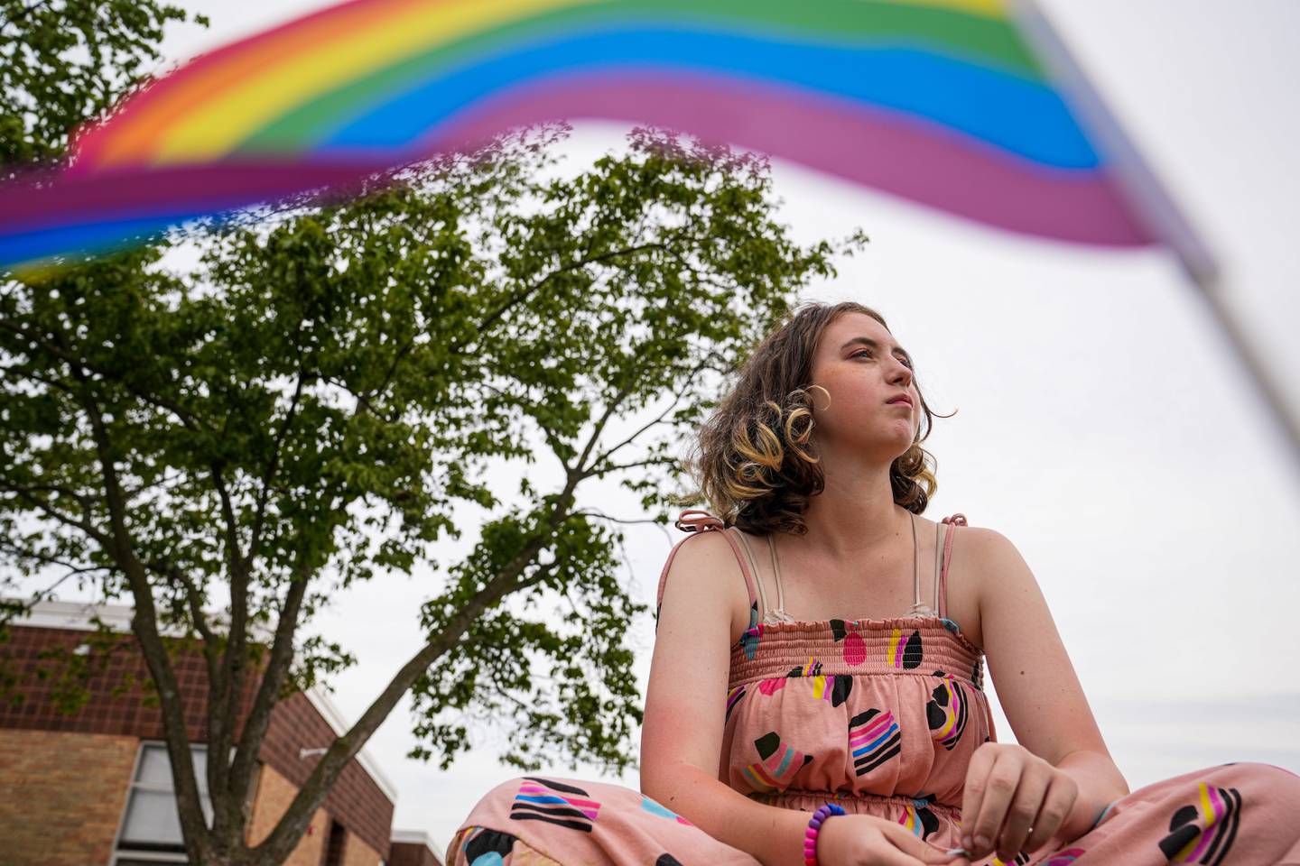 Ash Tough, 13, framed by a Pride flag, sits for a portrait outside of Northwest Middle School in Taneytown.