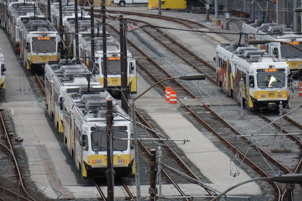 Six train cars idle on a lattice of train tracks.