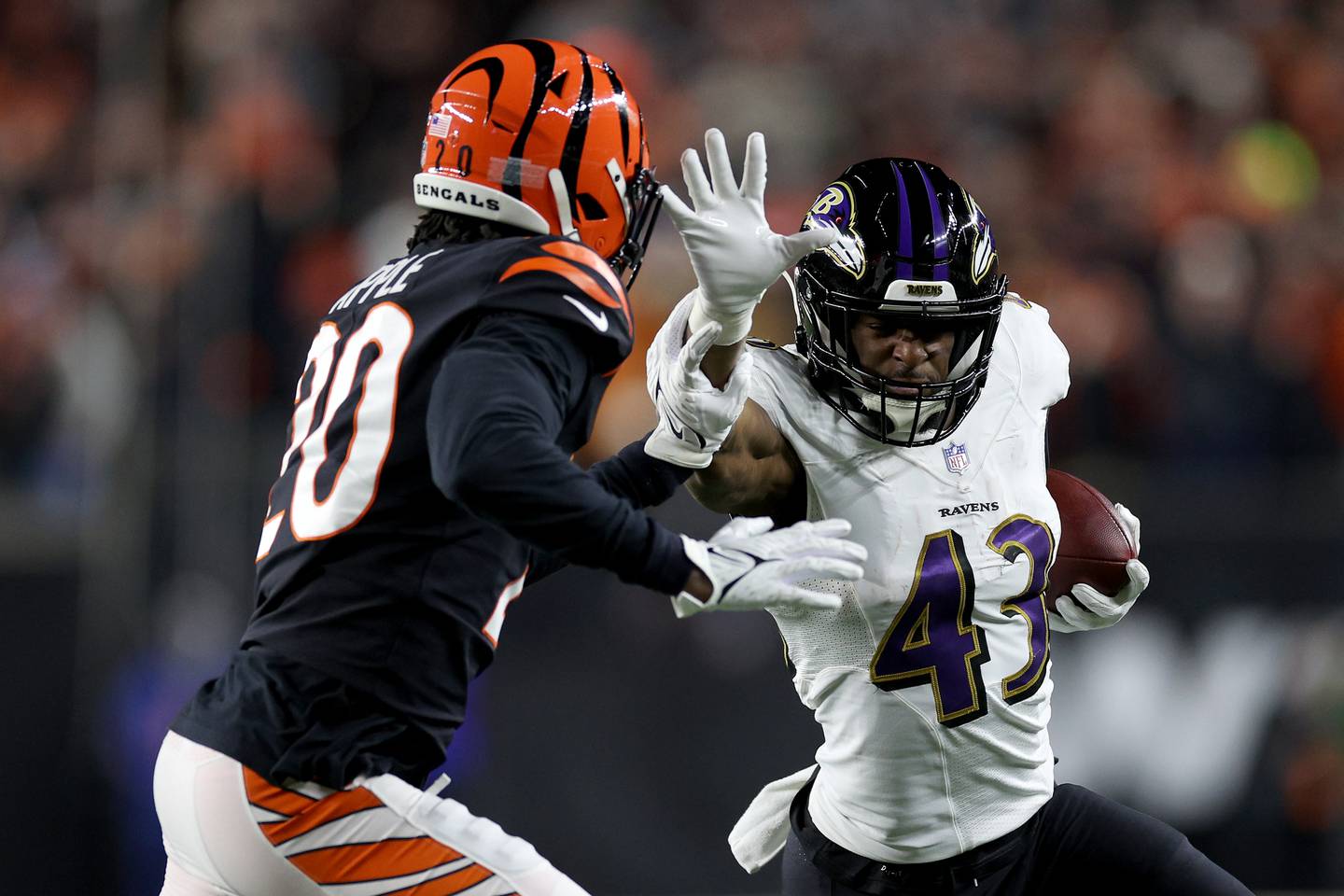 CINCINNATI, OHIO - JANUARY 15: Eli Apple #20 of the Cincinnati Bengals tackles Justice Hill #43 of the Baltimore Ravens during the fourth quarter in the AFC Wild Card playoff game at Paycor Stadium on January 15, 2023 in Cincinnati, Ohio.