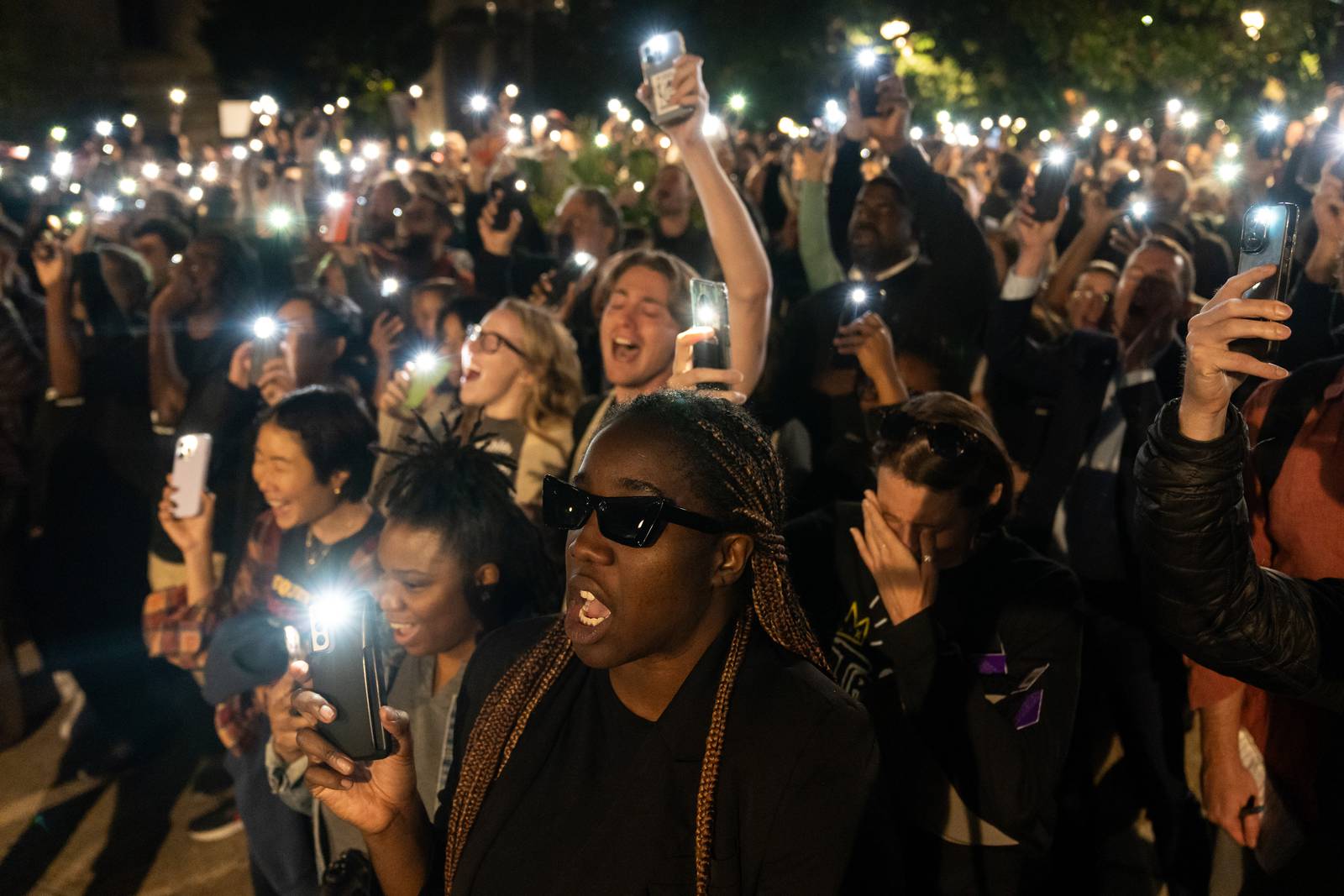The crowd shouts “We love you, Pava” while holding up their phone flashlights during a vigil for Pava LaPere at the Washington Monument on Wednesday, Sept. 27, 2023.
