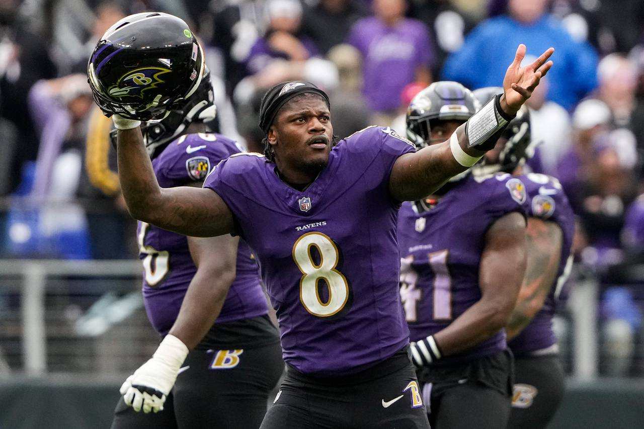 Lamar Jackson throws his hands up in the air as he watches the replay of his incomplete pass.