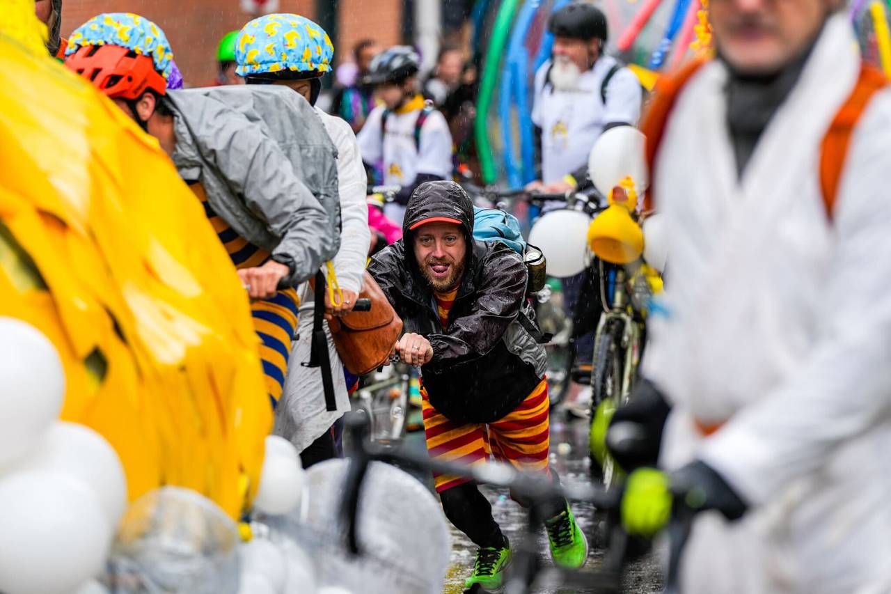 A biker pants as they push the "Tail-or-Swiftie" rubber duck sculpture up Battery Avenue as part of the Kinetic Sculpture Race on May 4, 2024.