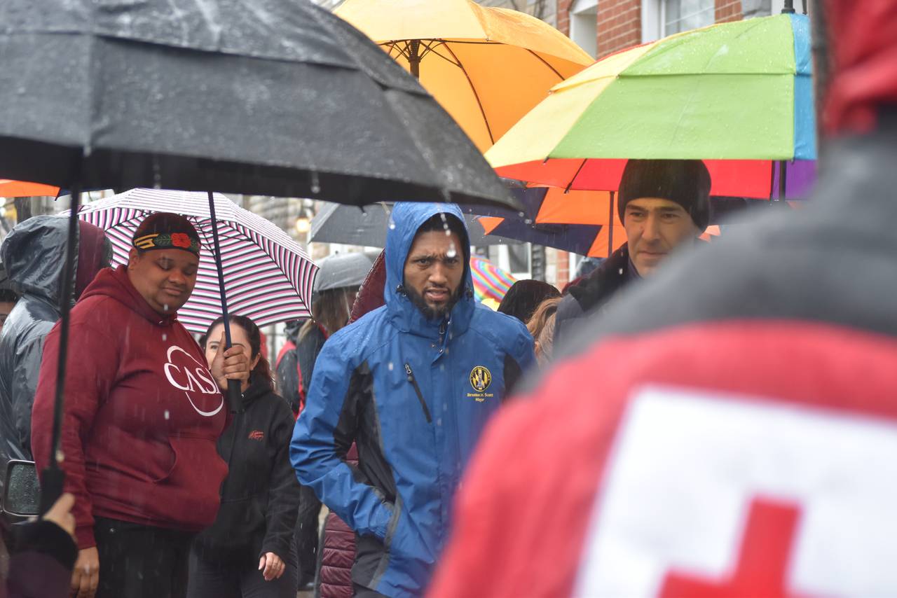 Baltimore Mayor Brandon Scott walks with City Councilman Zeke Cohen along E. Lombard Street on a rainy Saturday morning to speak with residents about fire safety.