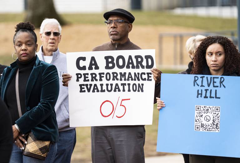 Larry Walker of Howard County holds a sign while speakers speak during a press conference in Downtown Columbia Lakefront, Monday, January 2, 2023.