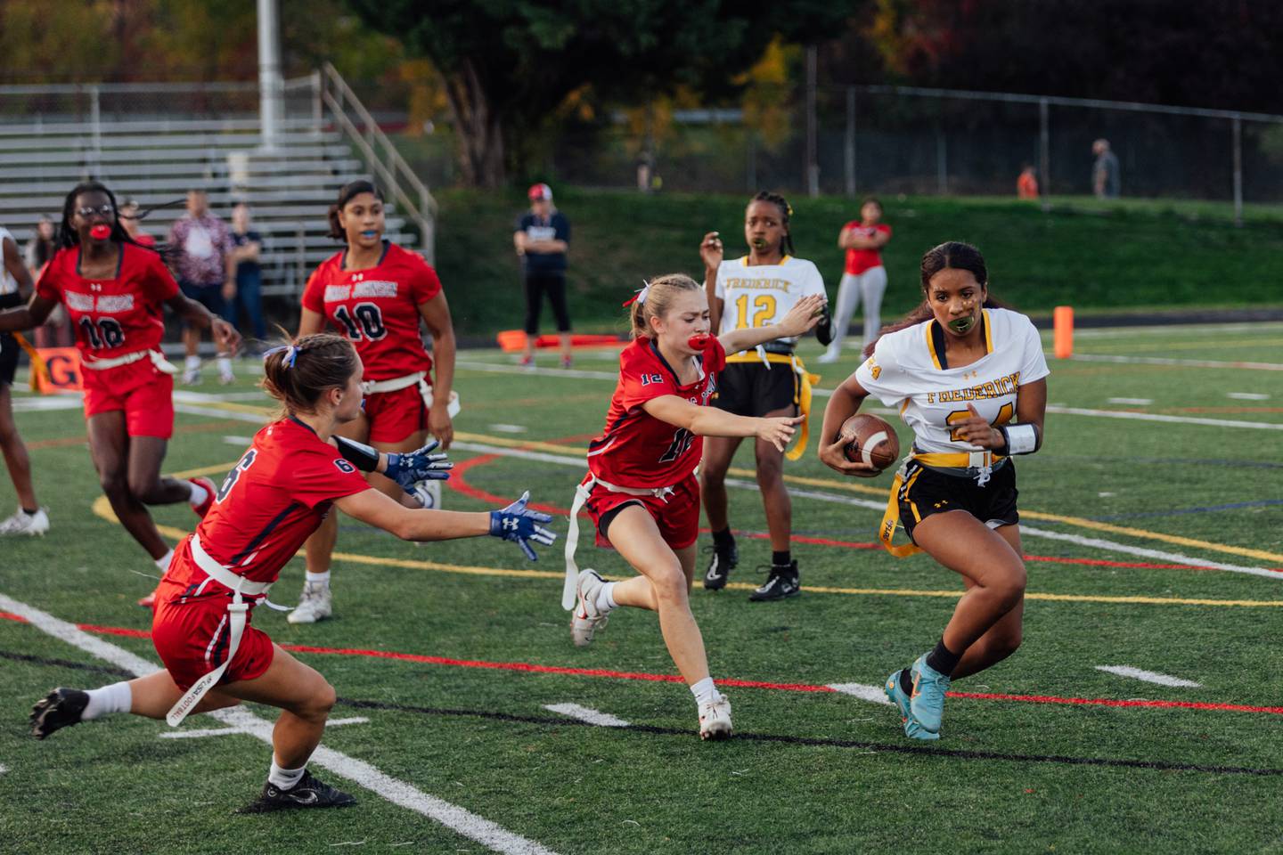 Frederick County Cadets freshman Maya Robinson runs the ball against the Thomas Johnson Patriots during the final minutes of regular season play in the girls varsity flag football season at Thomas Johnson High School, on Thursday, Oct. 26, 2023 in Frederick, MD. (Wesley Lapointe / for the Baltimore Banner)