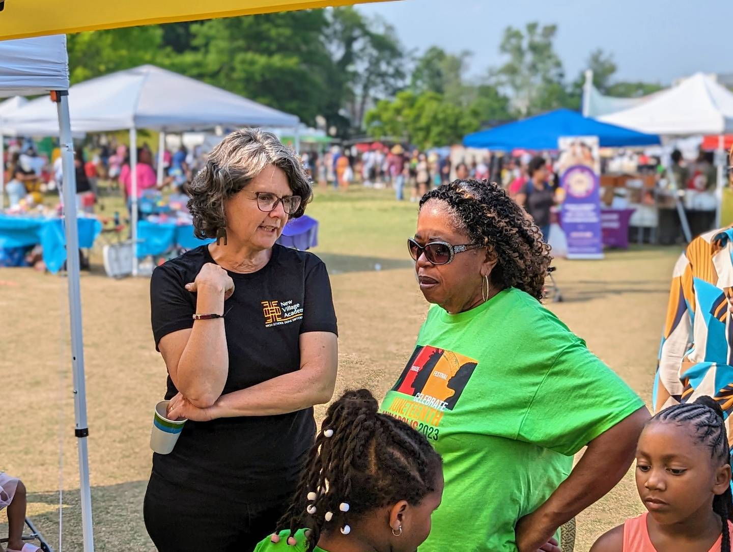 Romey Pittman, left, talks with a parent about New Village Academy, a proposed charter school in Annapolis, during the Juneteenth festival on Saturday.