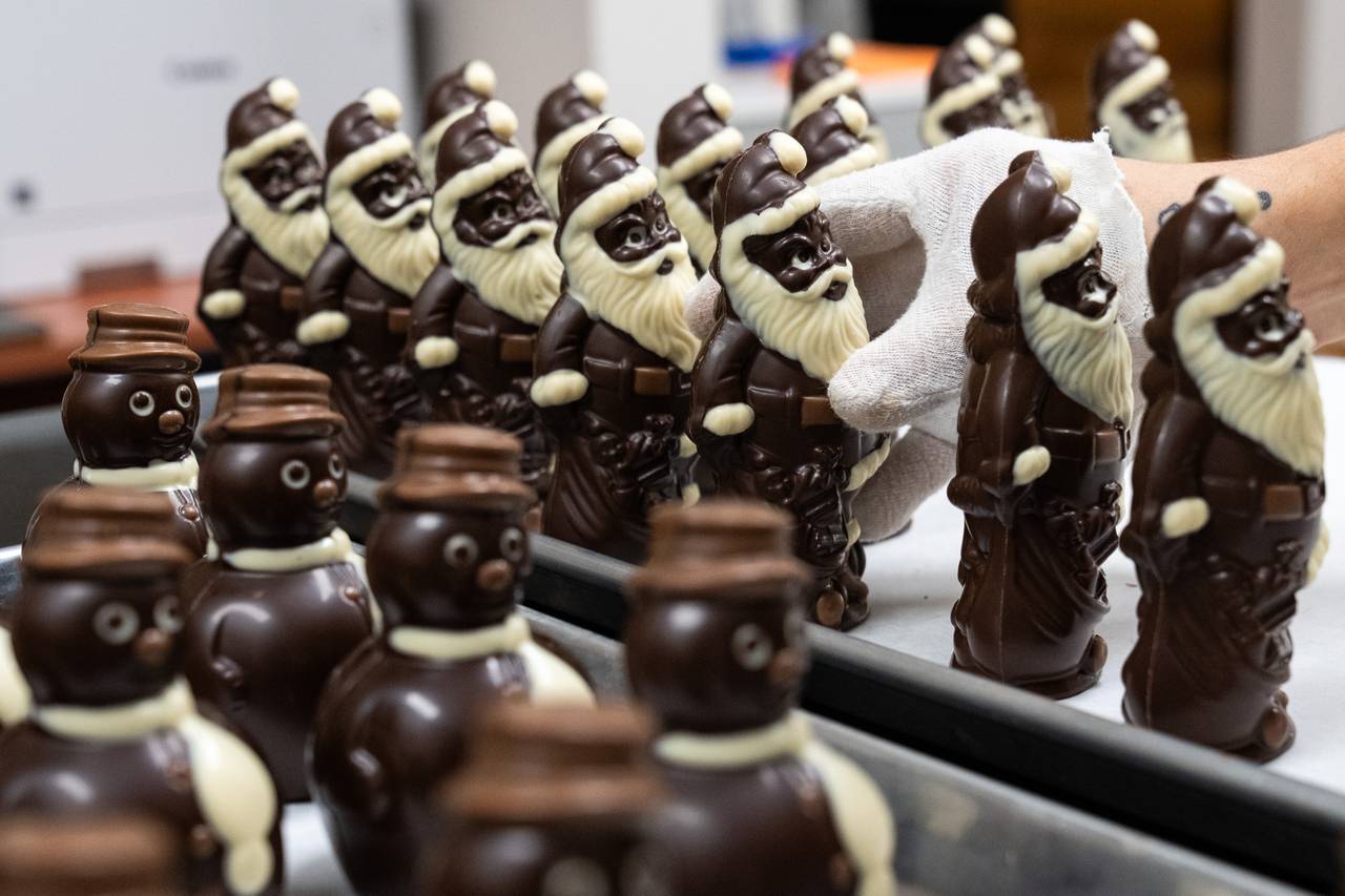 Joey Russell, owner Miyoko Russell’s son and holiday employee, sets a freshly-made dark chocolate Santa into a row of others on a tray.