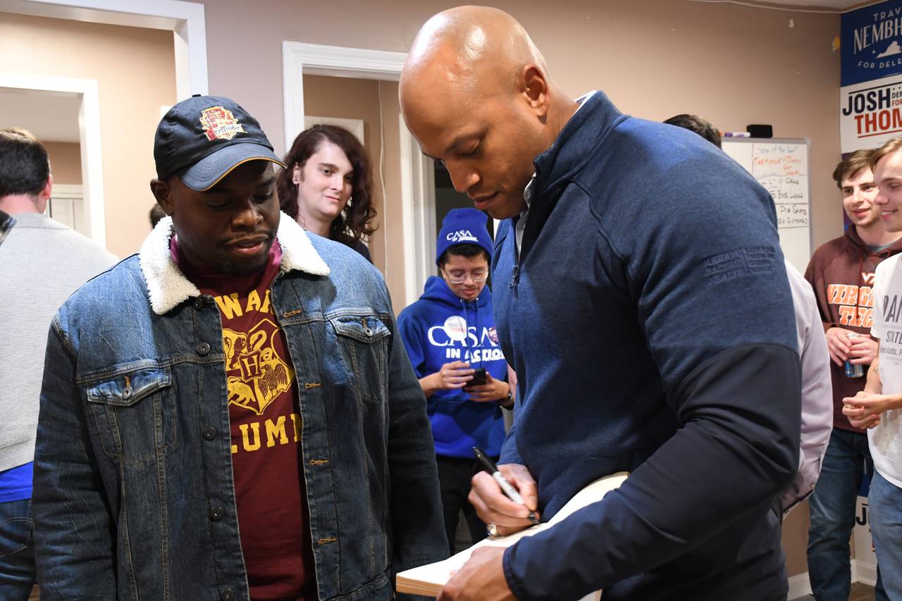 Maryland Gov. Wes Moore signs a copy of his book, "The Other Wes Moore," for Steve Voltaire while supporting Democratic candidates in Manassas, Va., on Saturday, Nov. 4, 2023.