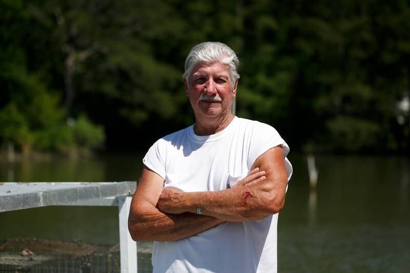 Crabber JC Hudgins is photographed by his boat in Mathews, Va., on Friday, June 10, 2022.