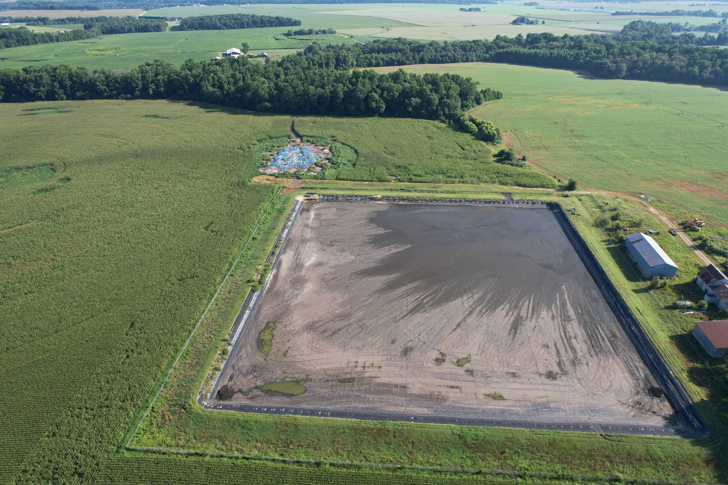 A large pit drained for the use of industrial sludge storage.