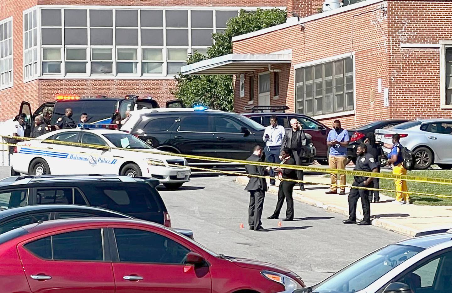 Police officer stand at two evidence markers during a shooting at Mergenthaler vocational high school  with major police presence.