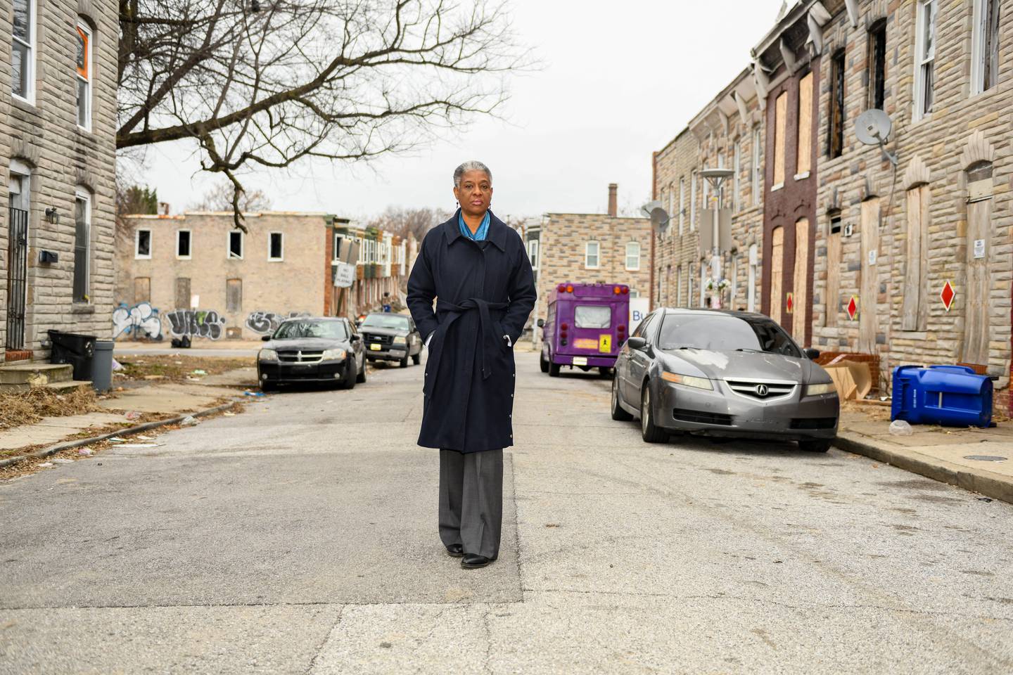 Claudia Wilson Randall takes a portrait in front of a block of homes in West Baltimore that have been sold off through tax sales, a system Randall has been fighting to reform in Baltimore City, January 25, 2023.