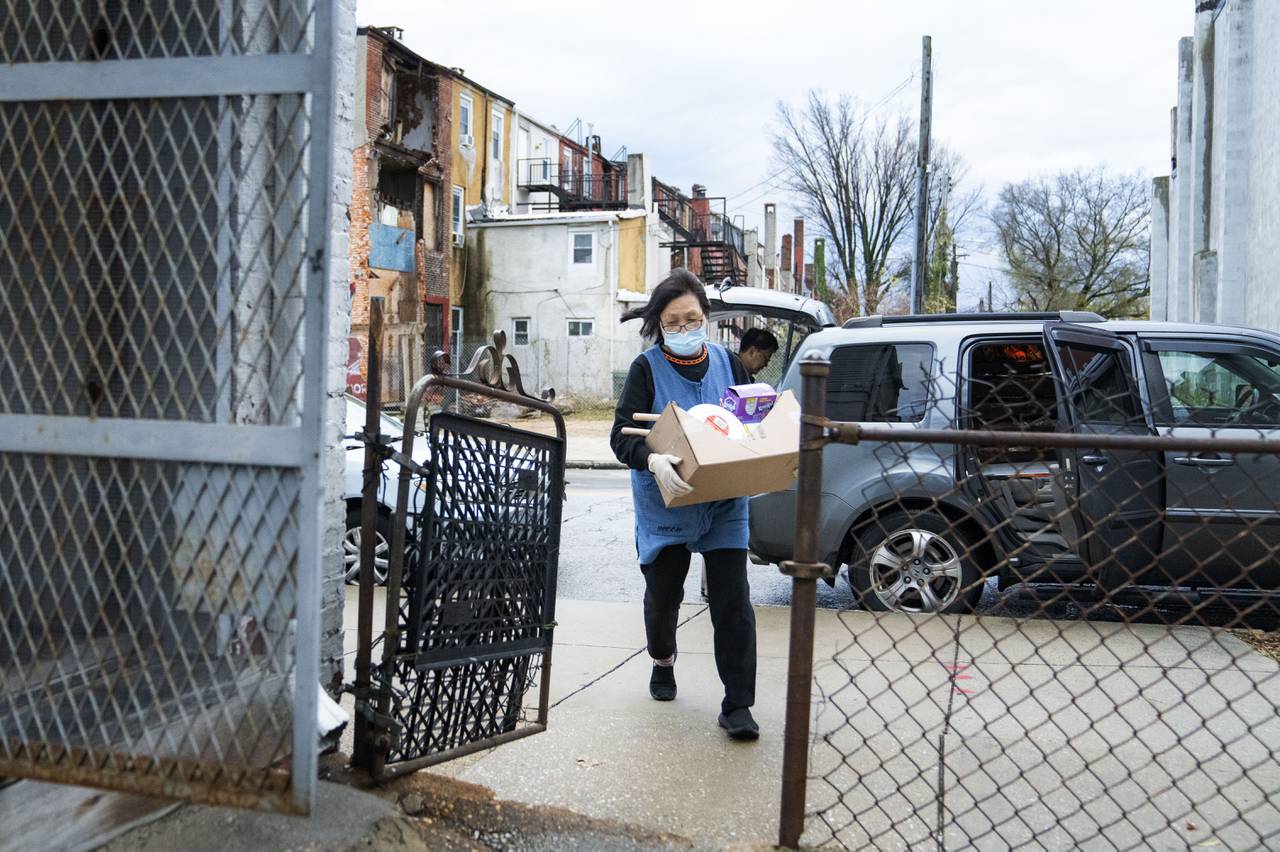 Tae Soon Lee carries in groceries into Lee's Mini Market, in Baltimore, Thursday, December 1, 2022.