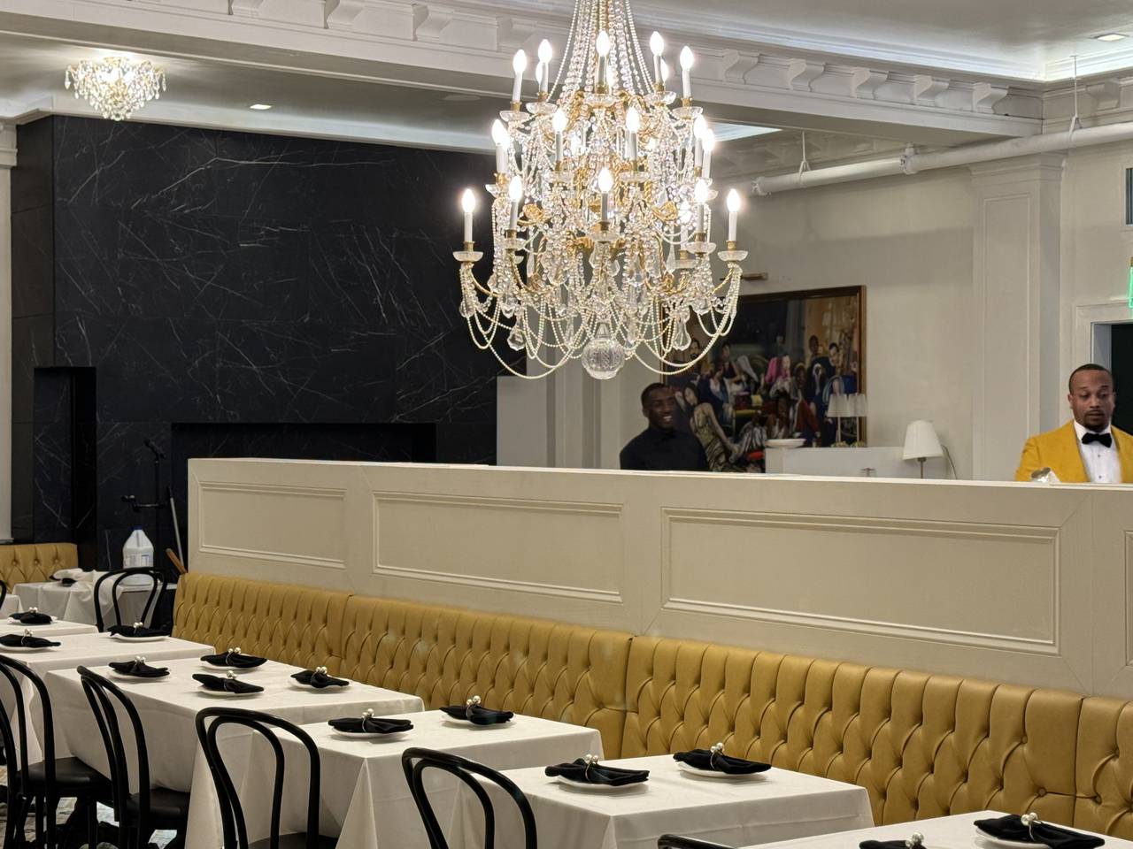 Prim and Proper's dining room is adorned with chandeliers and golden booths.