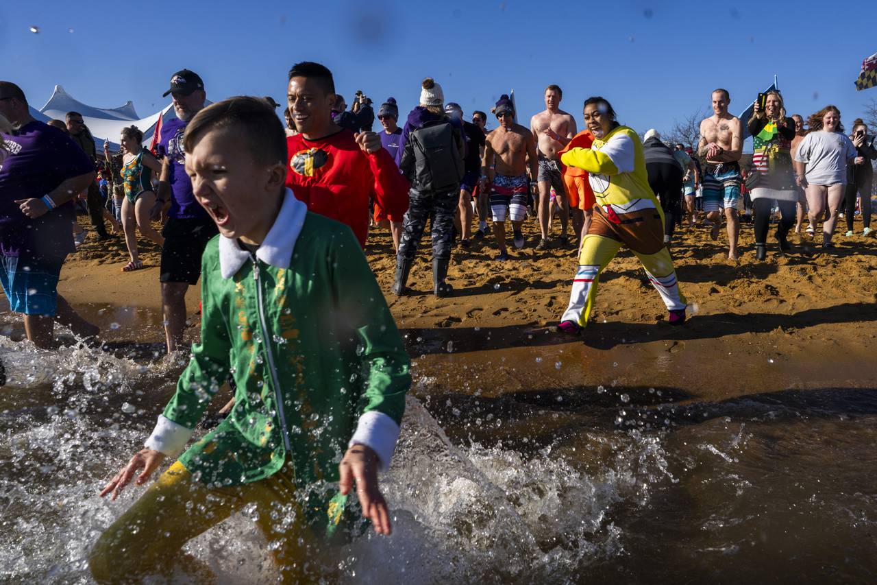 A boy dressed as "Elf" yells as he submerges himself into the cold bay.