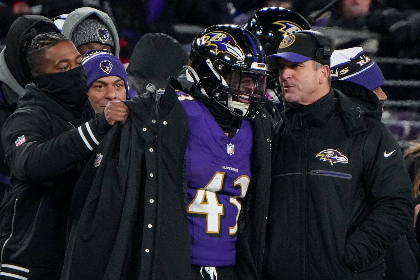 Baltimore Ravens running back Justice Hill (43) and head coach John Harbaugh share a laugh together on the sidelines of a playoff game against the Houston Texans at M&T Bank Stadium on January 20, 2024.