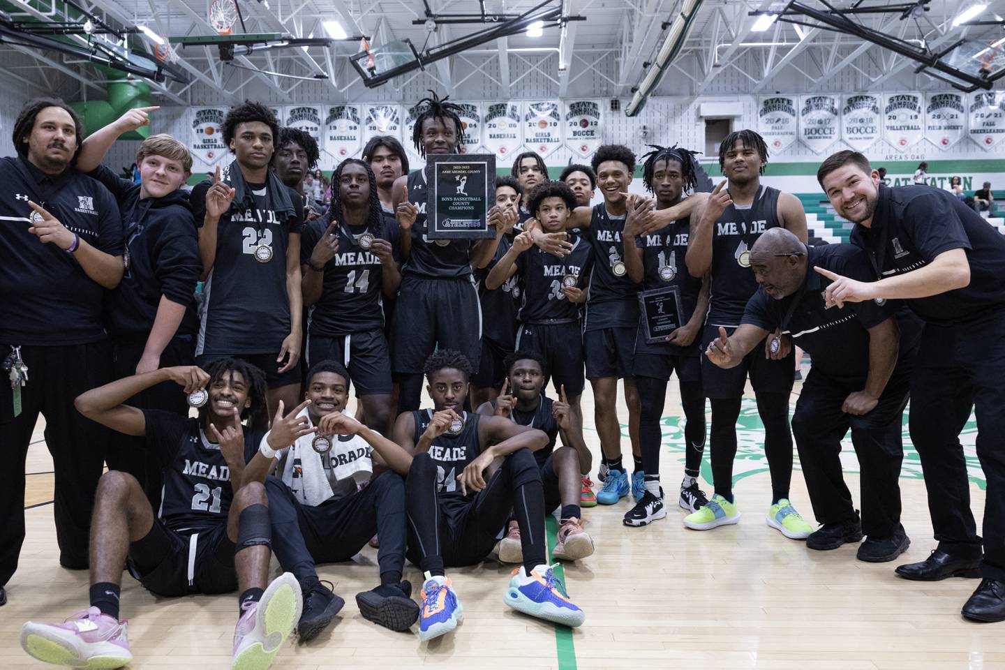Meade players and coaches pose for a photo following their victory in the Anne Arundel County Boys Basketball Championship game in Odenton, Md., on Saturday, February 18, 2023.  Meade defeated Broadneck 60-51 in regulation time to win the championship.