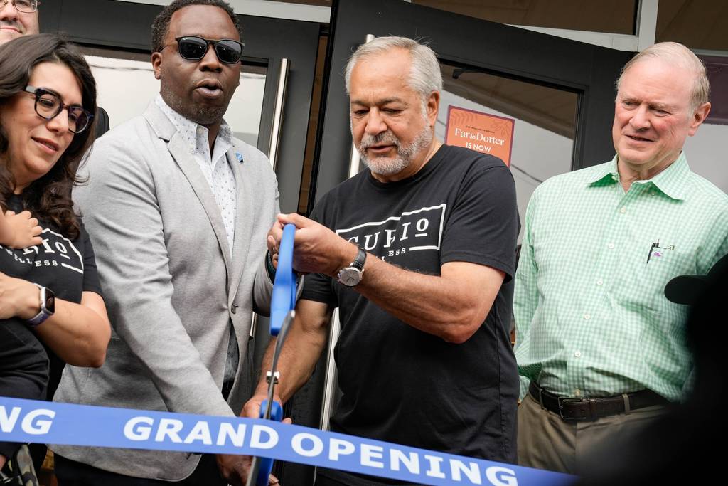 President of the Baltimore County Chamber of Commerce Brent Howard cuts the ribbon with the CEO of Curio Wellness at the recreational grand opening of Far & Dotter on July 1, 2023, the first day of recreational cannabis legalization in Maryland.