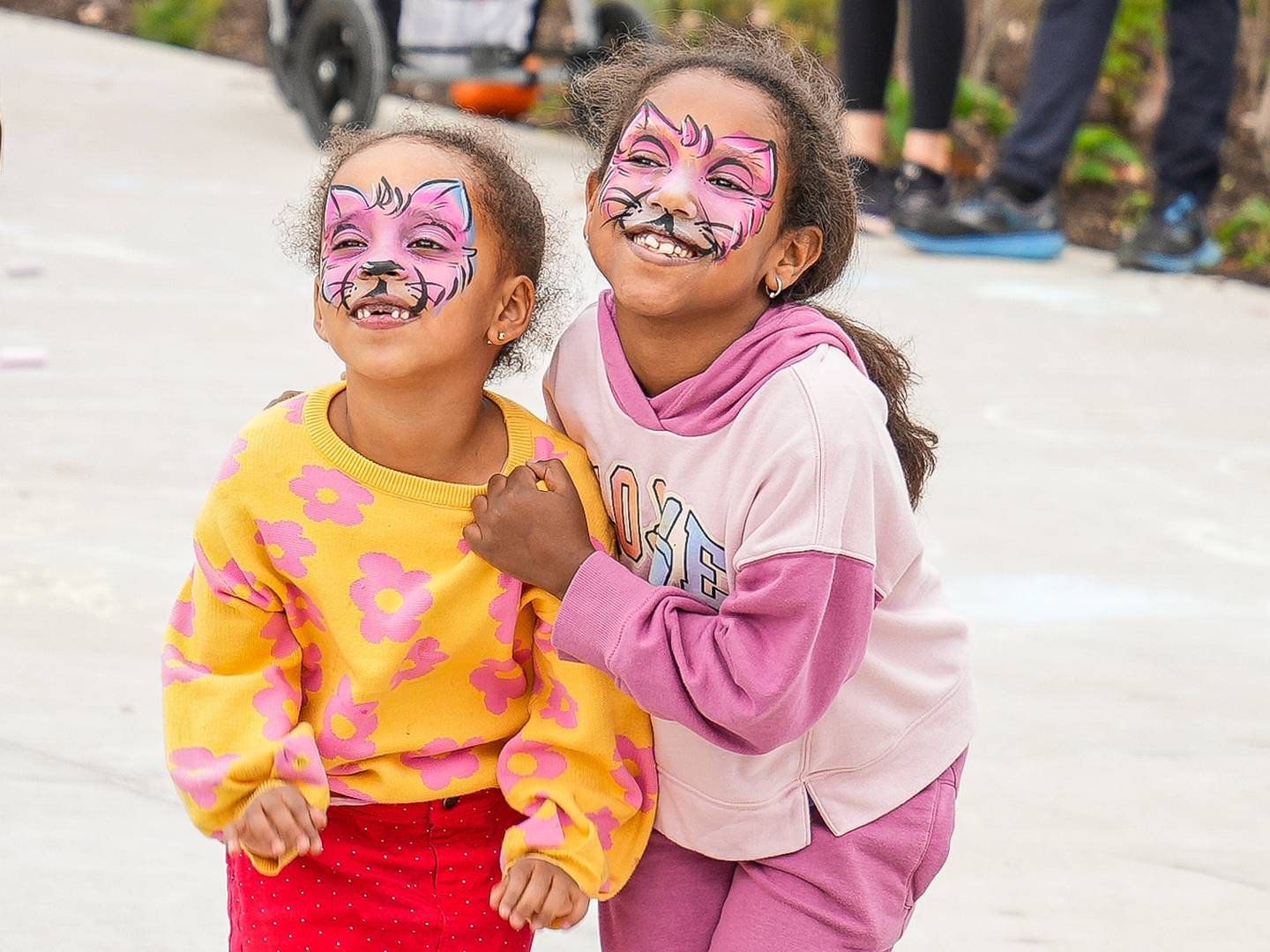 Emamda Tesfa (6) in pink and Meheret Yosias (4) in yellow take a photo in their freshly applied face paint.
