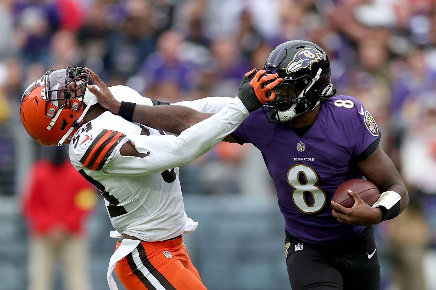 BALTIMORE, MARYLAND - OCTOBER 23: Quarterback Lamar Jackson #8 of the Baltimore Ravens stiff arms linebacker Deion Jones #54 of the Cleveland Browns in the second half at M&T Bank Stadium on October 23, 2022 in Baltimore, Maryland.