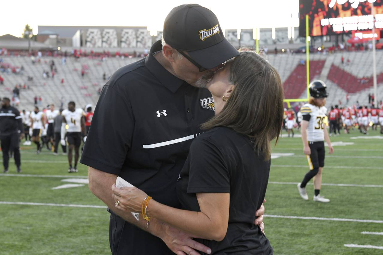 Towson head football coach Pete Shinnick kisses his wife, Traci, after an NCAA football game against Maryland on Saturday, Sept. 2, 2023, in College Park, Md. (AP Photo/Steve Ruark)