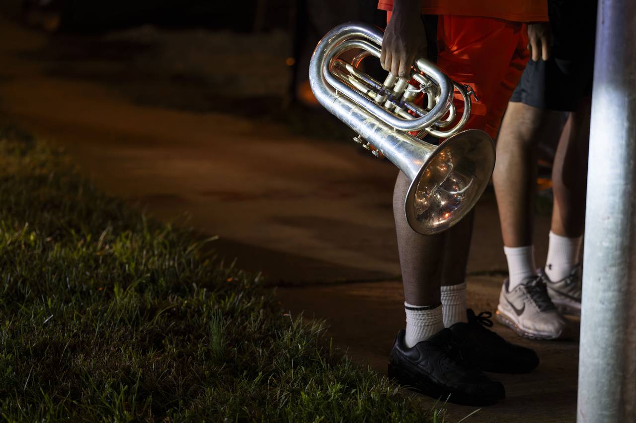 A student carries a cornet that reflects the light of police cars after a shooting incident at Morgan State University on October 3, 2023. The student had been required to shelter in place as police investigated.