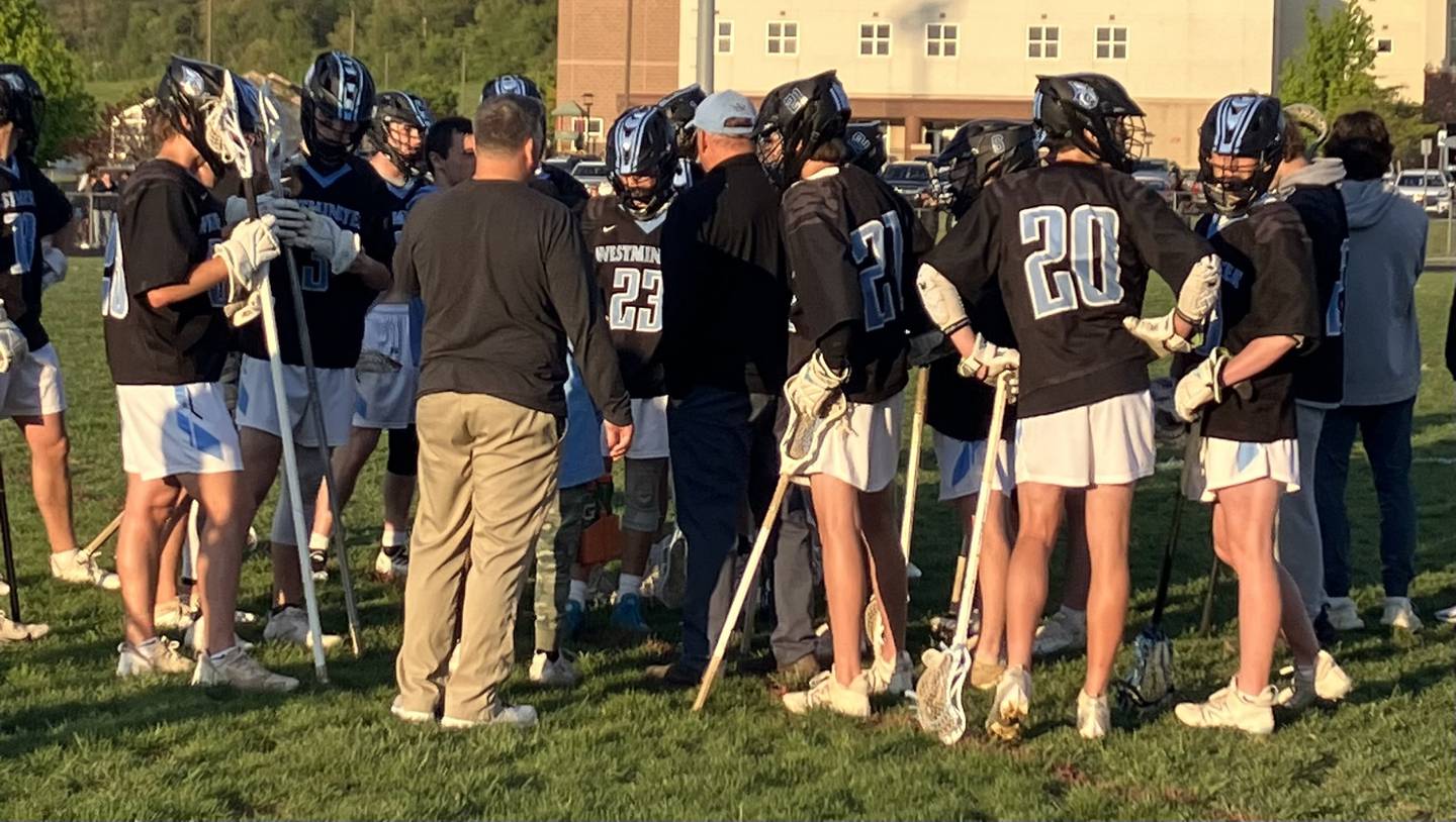 Westminster's boys lacrosse team gathers during a timeout in Tuesday evening's match at Winters Mill. The Owls remained undefeated in Carroll County Athletic League play with a 9-7 victory over the Falcons.