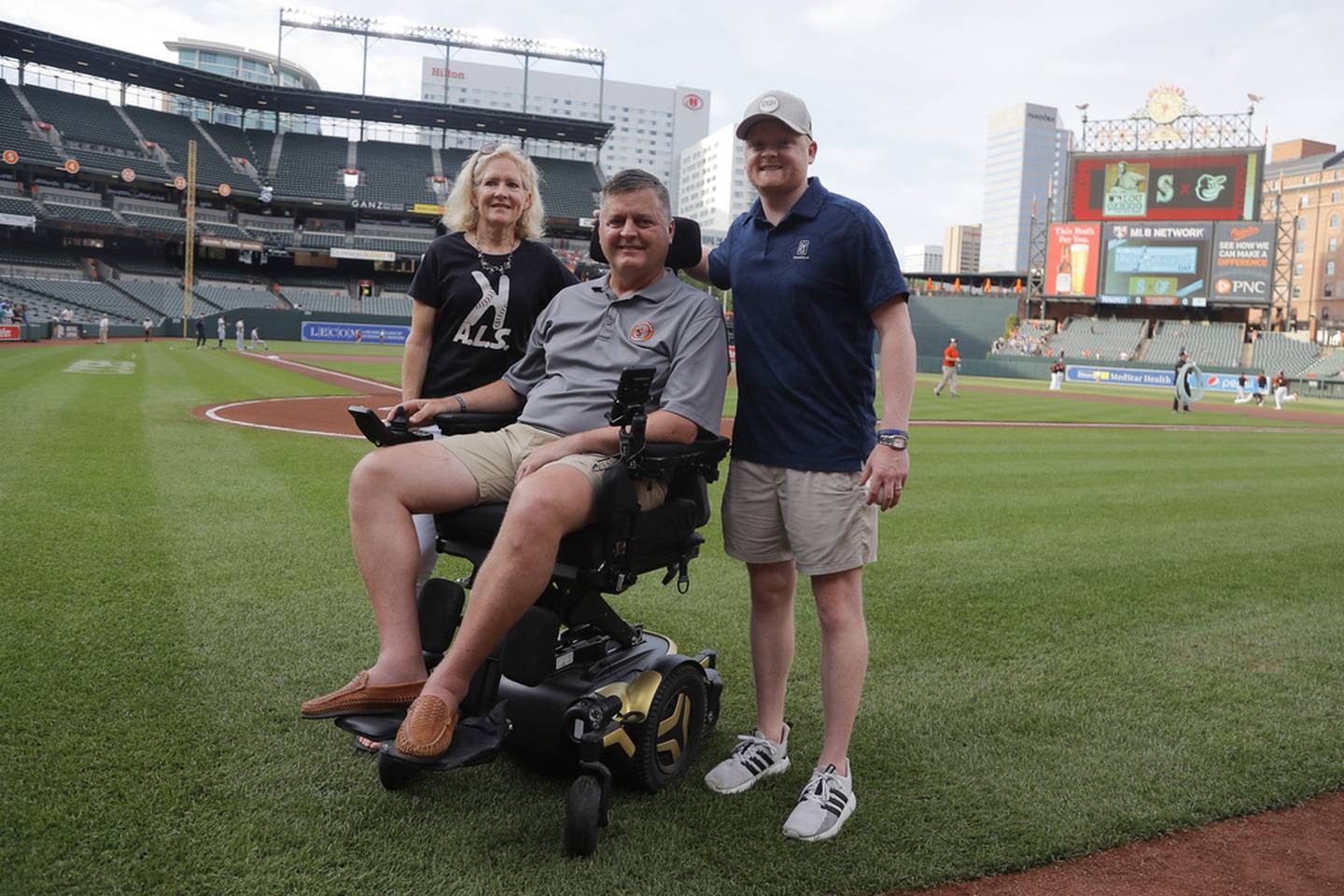 FILE - Former Baltimore Orioles pitcher Jim Poole, center, poses for a photo with his wife, Kim Poole, left, and their son Hayden Poole, prior to a baseball game between the Orioles and the Seattle Mariners, Thursday, June 2, 2022, in Baltimore. Poole, who pitched in the big leagues for 11 seasons and surrendered the deciding homer to Atlanta's David Justice in the 1995 World Series, died of complications from ALS, Friday, Oct. 6, 2023. He was 57.