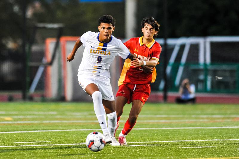 Loyola’s Sammie Walker and Calvert Hall’s Rocco Pastore battle for the ball on Wednesday night.