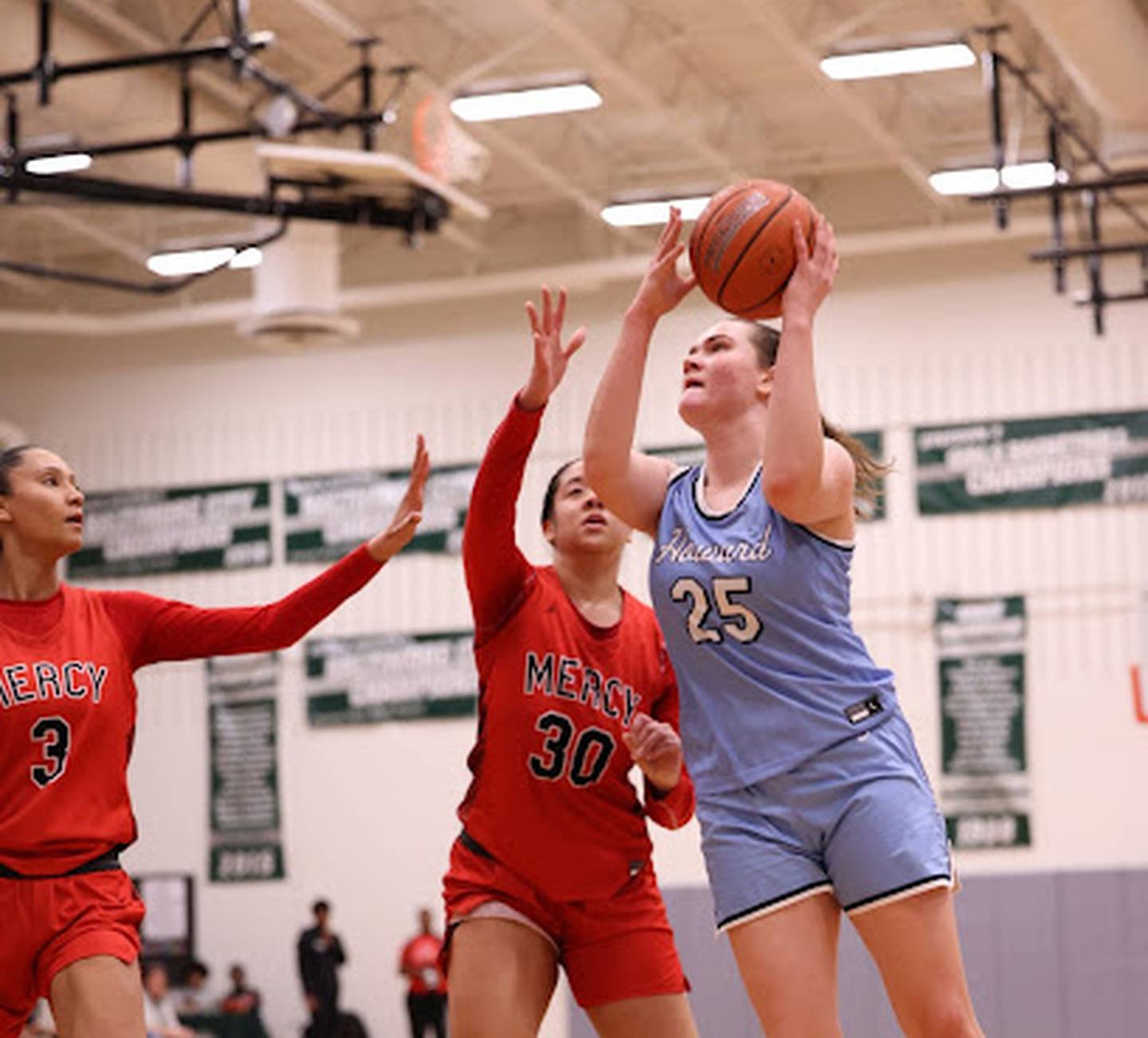 Howard's Megan Yarnevich puts up a shot as Mercy's Myah Hazelton (left) and Mckenna Carroll defends during Friday's Kim Harris Division title match at the All About the Girls Holiday Hoops tournament at Forest Park. Yarnevich finished with 15 points and nine rebounds as the No. 5 Lions won their 47th straight regular season decision with a 43-39 victory over the 8th-ranked Magic.