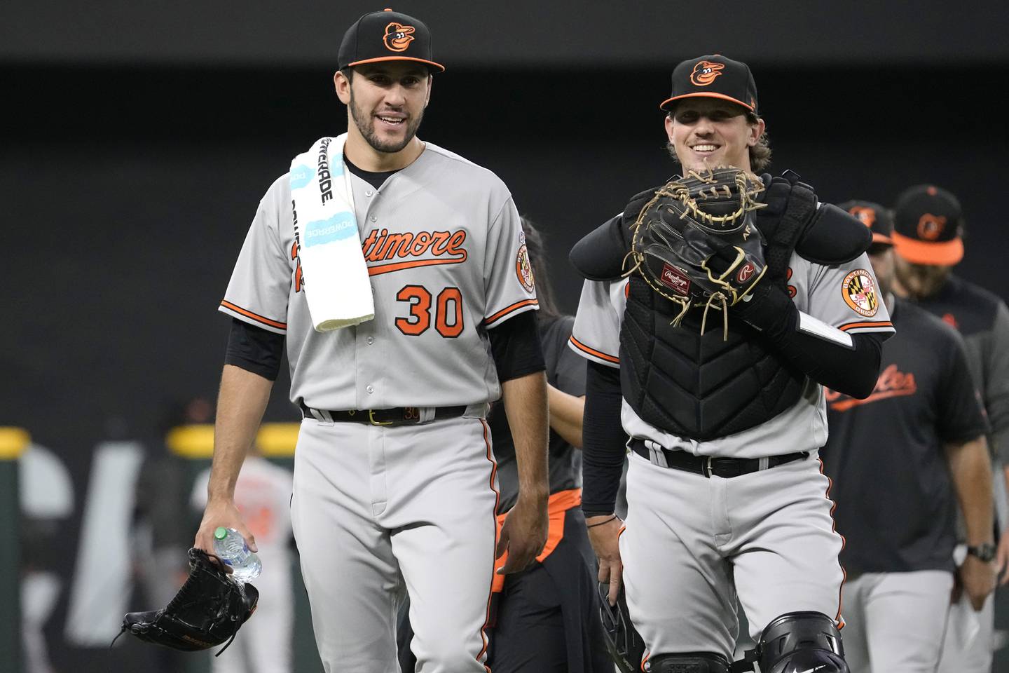 ARLINGTON, TEXAS - APRIL 05: Grayson Rodriguez #30 of the Baltimore Orioles and Adley Rutschman #35 walk back to the dugout ahead of Rodriguez' Major League debut game against the Texas Rangers  at Globe Life Field on April 05, 2023 in Arlington, Texas.