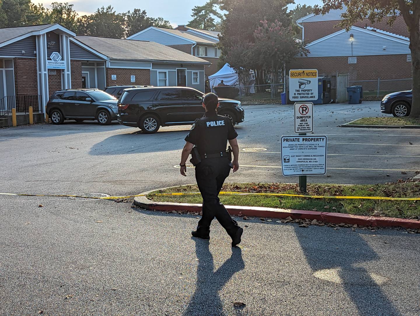An Annapolis police officer walks past the parking lot of the Boys and Girls Club in the Bywater neighborhood after an 18-year-old Glen Burnie man was shot to death in a courtyard next door on Friday, Sept. 8.