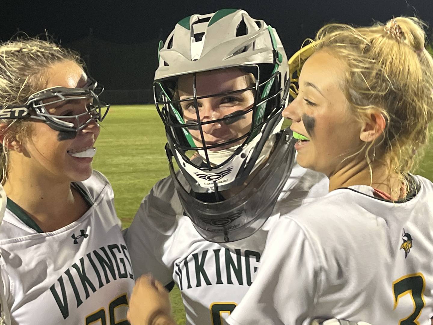 St. John's Catholic's Addison Scanlon (left) and Juliana Workman is congratulated by teammate Rylan Piccolo after Saturday evening's IAAM B Conference lacrosse championship game. Scanlon's free position score with about two minutes left in overtime gave the Vikings a 11-10 victory over Park at USA Lacrosse's Tierney Field.