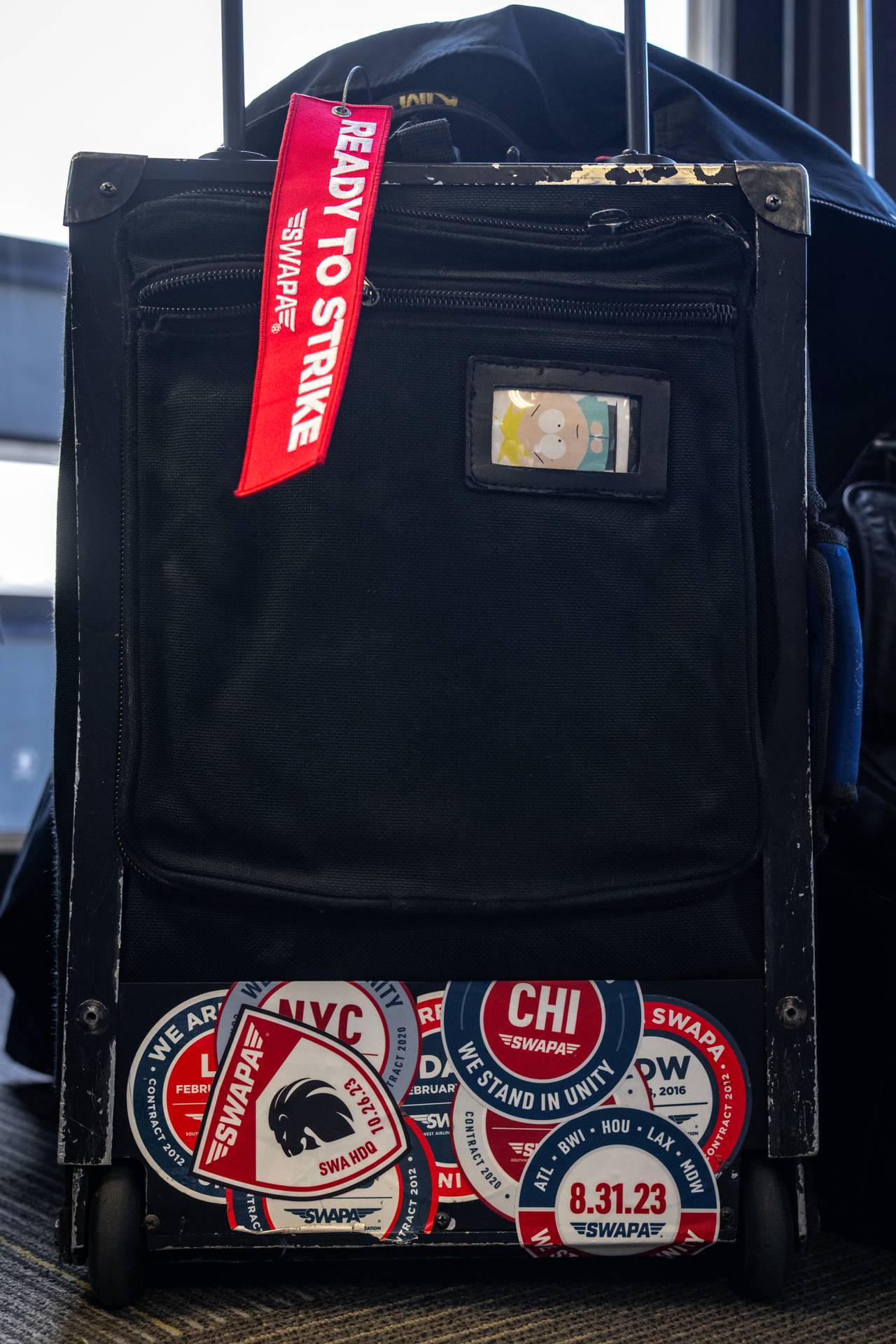 A pilot’s suitcase has a variety of stickers and a luggage tag in support of the Southwest Airlines Pilots Association union.
