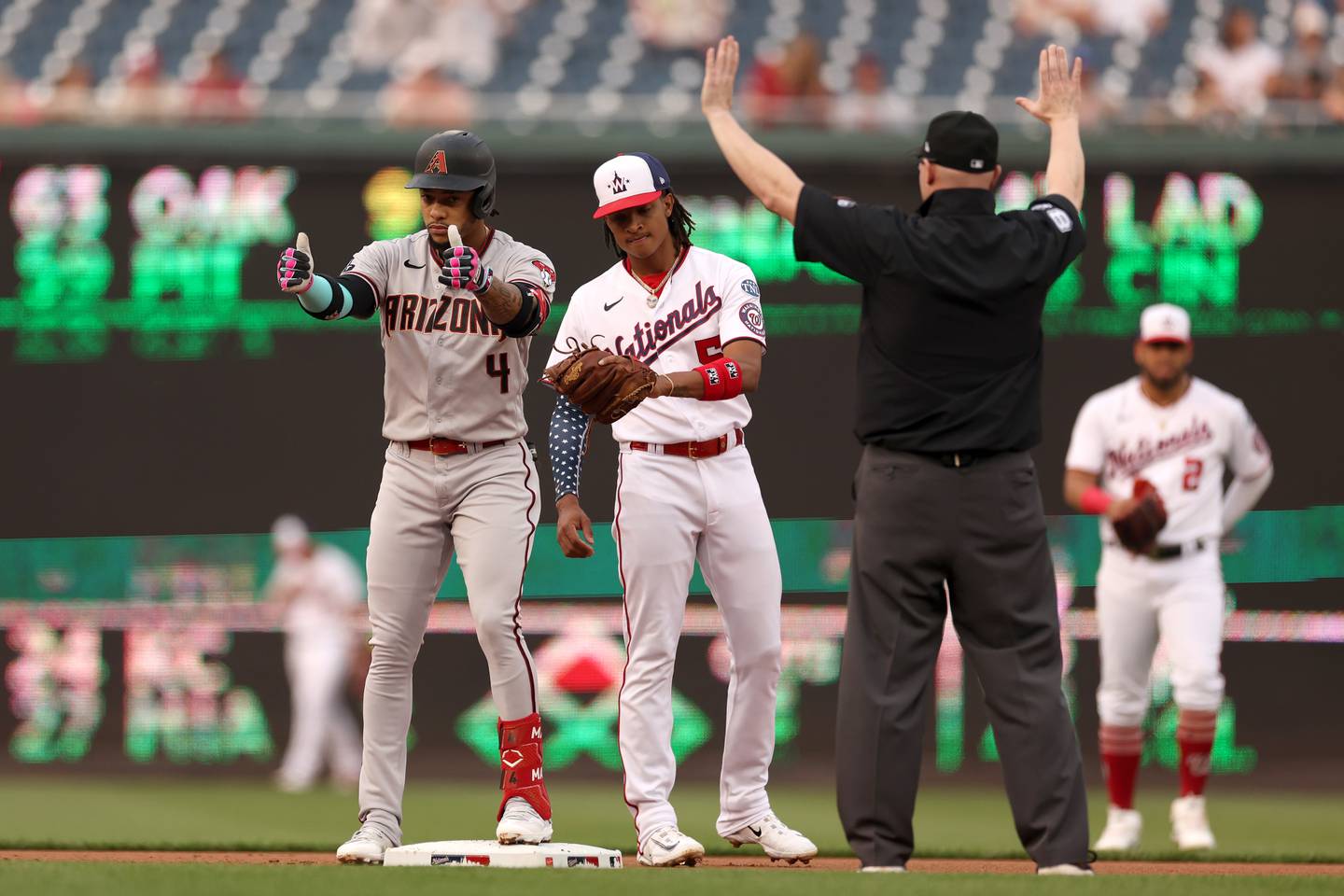 WASHINGTON, DC - JUNE 07: Ketel Marte #4 of the Arizona Diamondbacks celebrates toward the dugout in front of CJ Abrams #5 of the Washington Nationals after doubling in the first inning at Nationals Park on June 07, 2023 in Washington, DC.